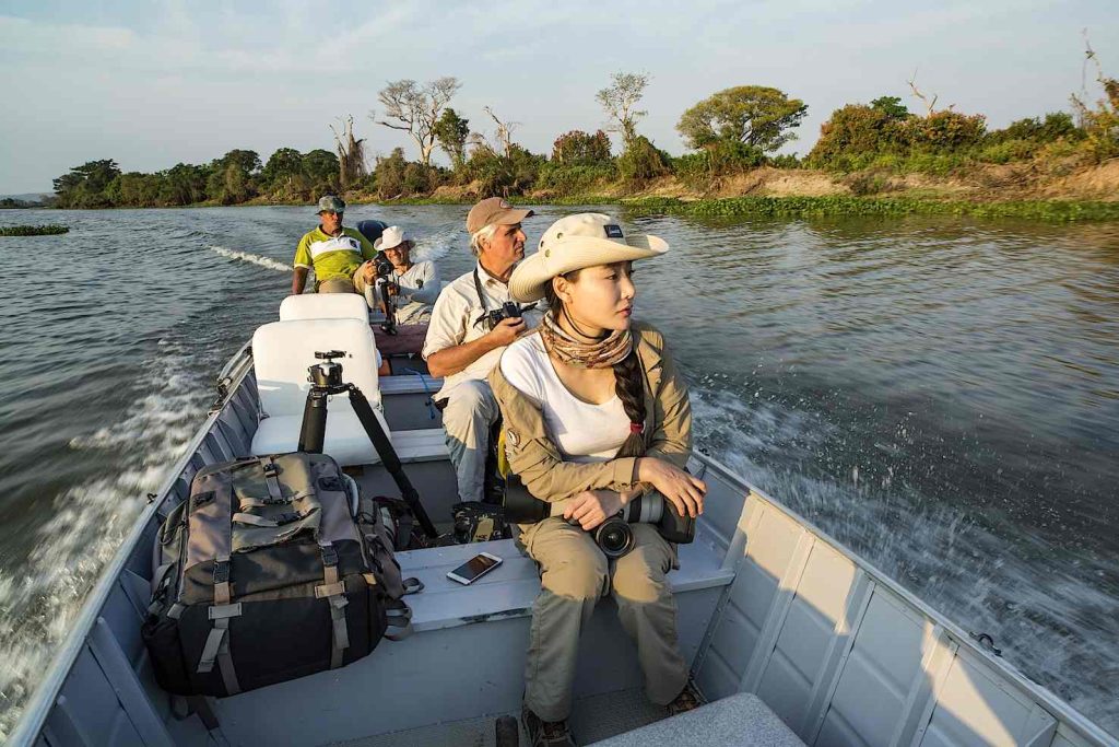 Turista durante un safari in barca sull’affluente collegato al fiume Paraguay, zone umide del Pantanal, Mato Grosso, Brasile (Franco Banfi)