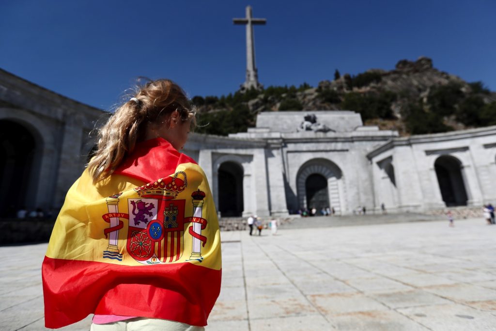 Una donna avvolta nella bandiera spagnola davanti al mausoleo El Valle de los Caìdos nei pressi di Madrid dove è sepolto Franco (Keystone)