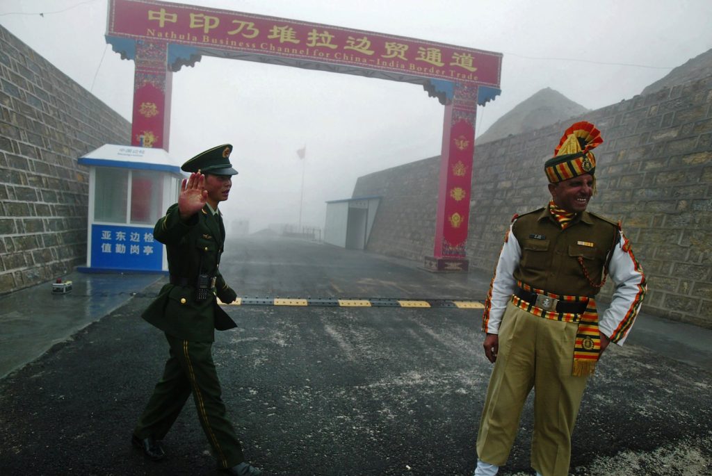 Un soldato cinese e uno indiano al confine di Nathu La fra India a Cina (AFP)