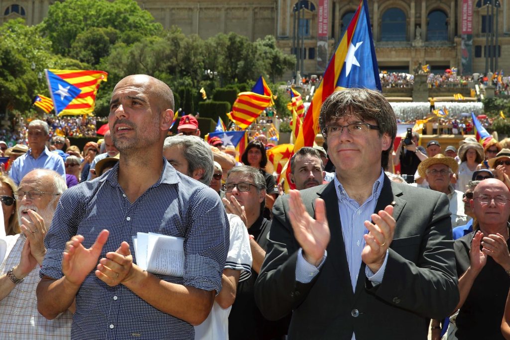 L'icona del calcio Pep Guardiaola (a sinistra) con il presidente catalano Carles Puigdemont davanti a migliaia di sostenitori dell'indipendenza (Keystone)