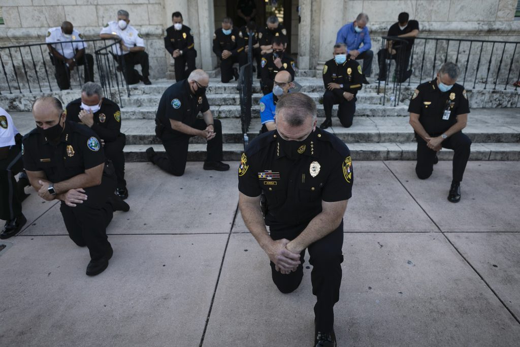 Agenti di polizia della contea di Miami-Dade si sono uniti a Coral Gables ai manifestanti pacifici in una preghiera per George Floyd (AFP)