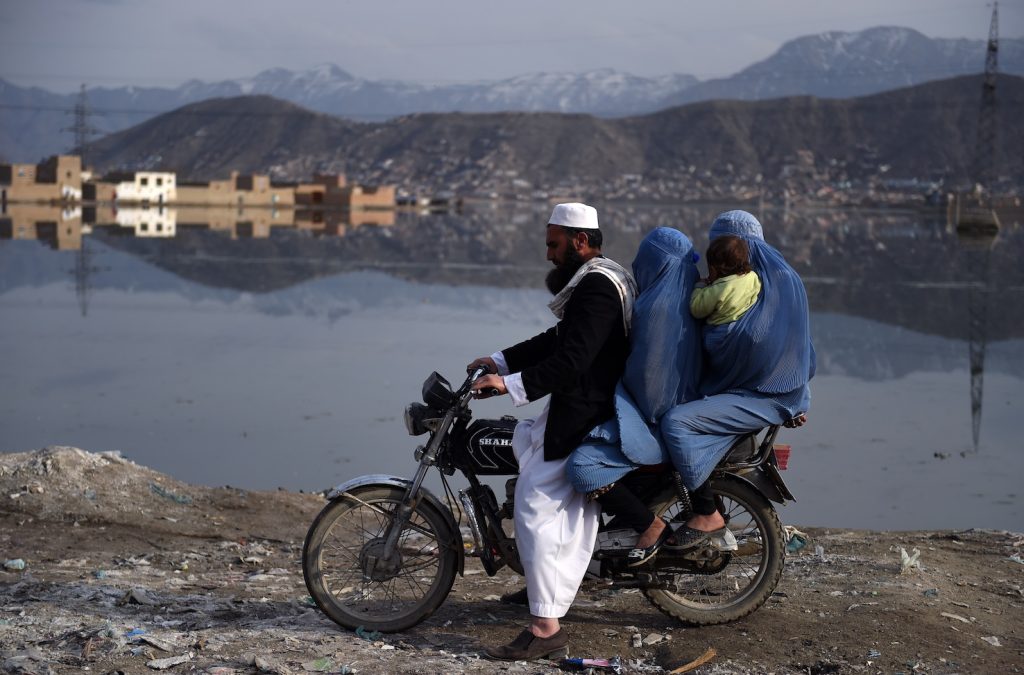 Una famiglia  viaggia su un motorino nei pressi del Lago Shuhada a Kabul (AFP)
