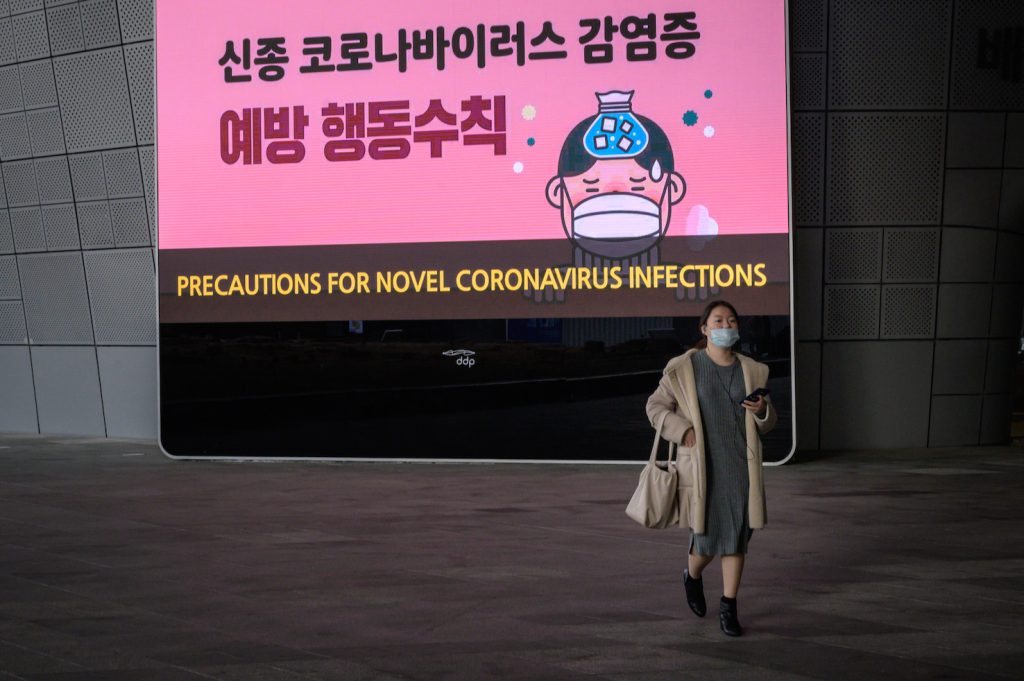 Una passante con la mascherina al Dongdaemuna Design Plaza a Seul (AFP)