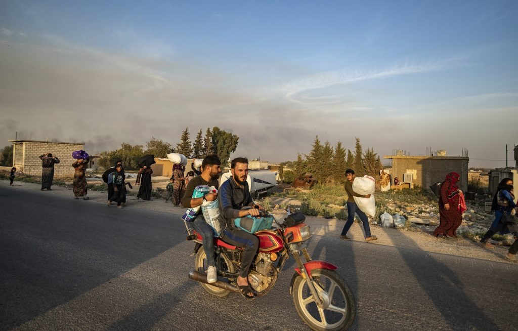 Civili curdi scappano dai bombardamenti turchi nella città siriana di Ras-al-Ain al confine con la Turchia (AFP)