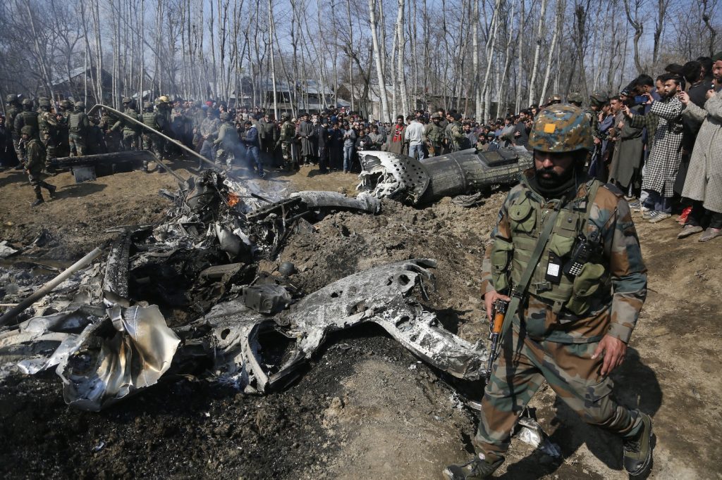 Soldati indiani ispezionano i rottami dell'aereo abbattuto per rotorsione dal Pakistan lungo il confine provvisorio che divide il Kashmir (Keystone)