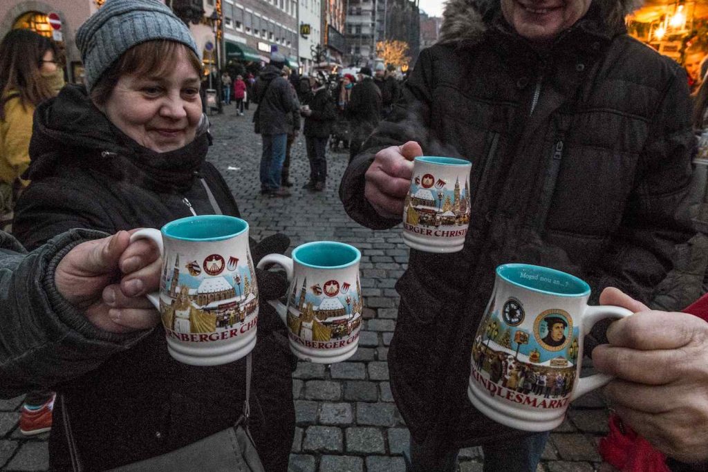 Visitatori con Glühwein nelle nuove tazze del 2017
