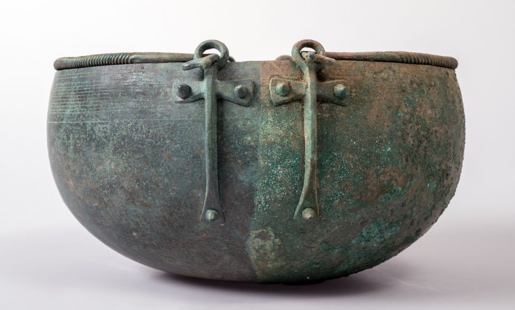 Calderone con attacchi a croce rivenuto in una tomba a Castaneda dove venne deposto avvolto in un panno funerario in cuoio attorno al 480 a.C.. Questa forma di recipiente in bronzo è conosciuta in tutta Europa, è però il primo trovato in Svizzera nella sua integrità (© Foto di Alberto Canepa)