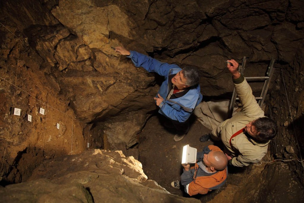 I ricercatori R. Roberts, V. Ulianov e M. Kozlikin pianificano la campionatura dei sedimenti in una grotta dei Denisova, Russia (IAET SB RAS / S. Zelensky)