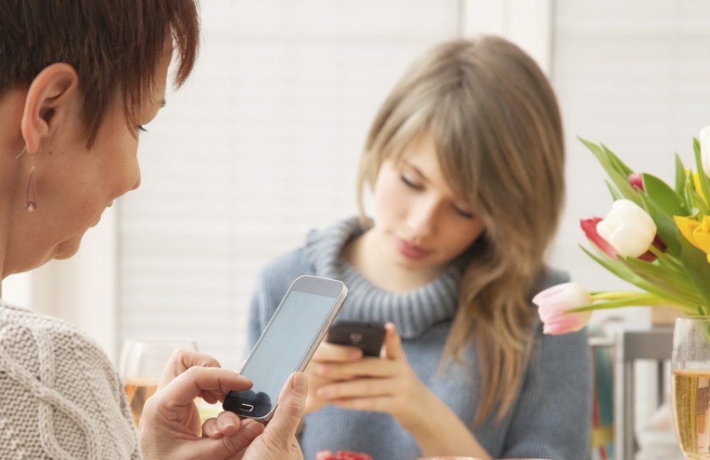 Non solo i ragazzi ma anche i genitori sono perennemente connessi con gli smartphone (Keystone)