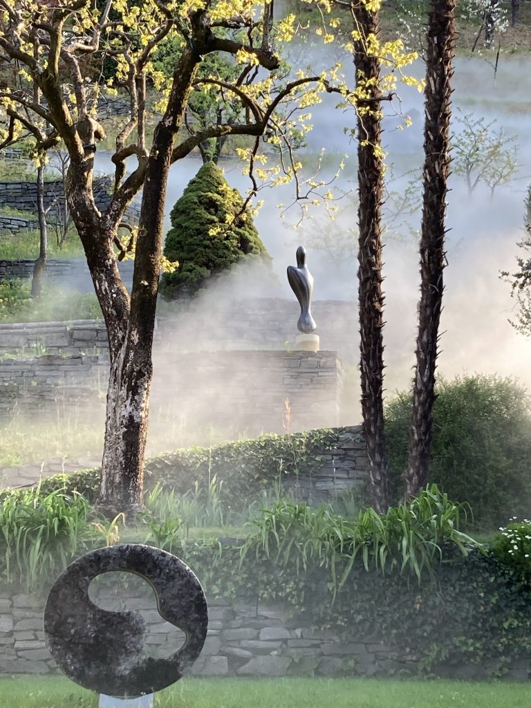 Giardino Ronco dei Fiori con l’installazione Nuvole dello Studio Nephos, la Ruota-foresta, granito belga (1961) e Essere alato, bronzo (1961). (@ Fondazione Marguerite Arp, Foto Simona Martinoli)