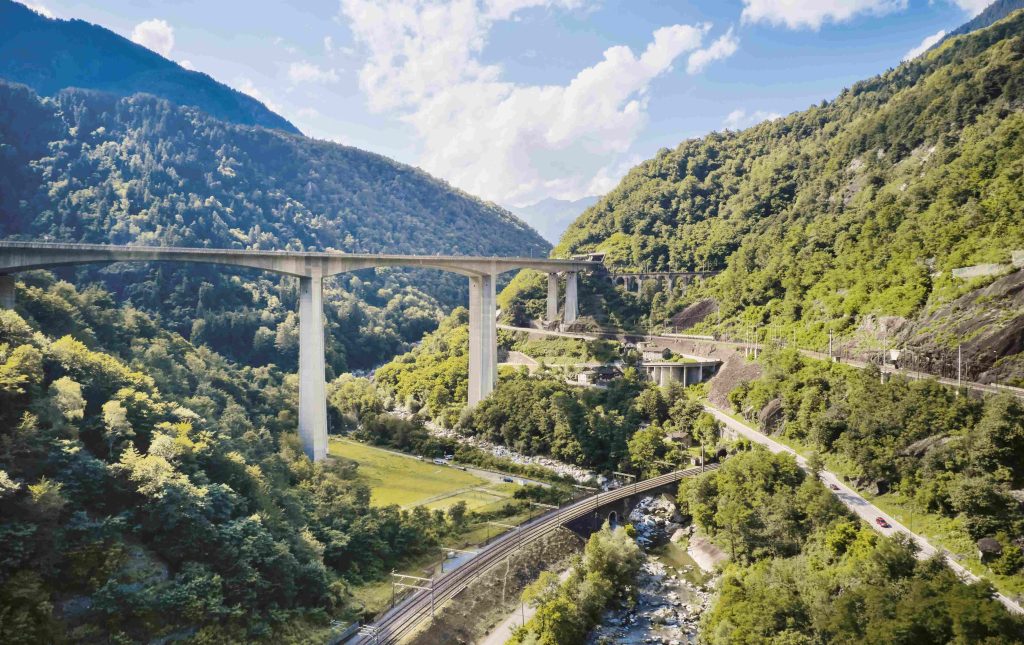 Le vie di comunicazione presso la gola della Biaschina, a Giornico, con le gallerie elicoidali ferroviarie, i tornanti della strada cantonale e il viadotto autostradale della Biaschina (© Tonatiuh Ambrosetti/Industriekultur.ch)
 
