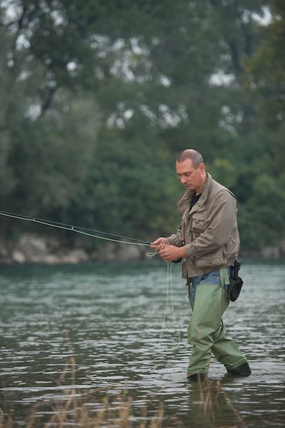 L’autore Raul Montanari a pesca, gli stivali nelle acque dell’Adda manzoniana