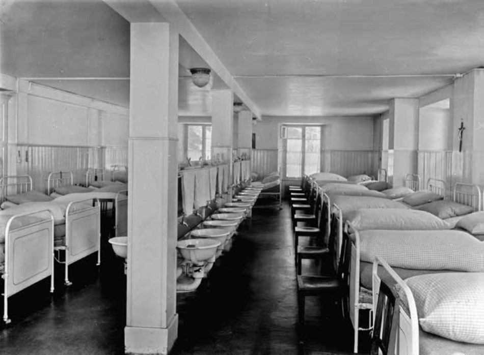 Dormitorio del convitto di Linthal, 1920: ogni ragazza ha la sua vaschetta ma non ci sono specchi "perché quella era vanità" (AARDT, fondo 148, Yvonne Pesenti)
