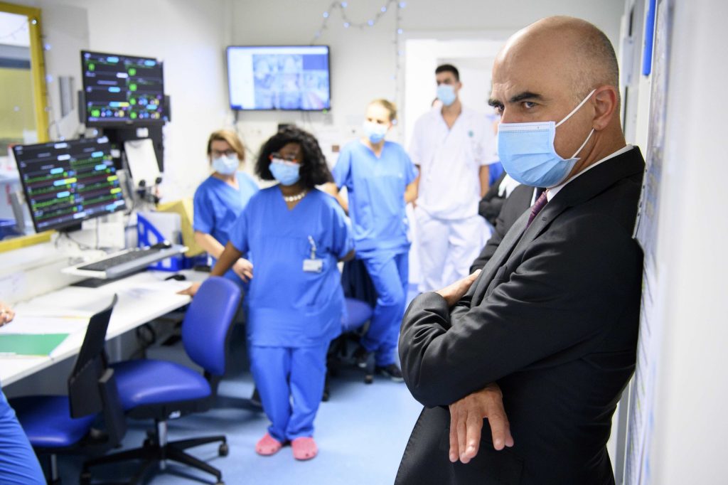 Il consigliere federale Alain Berset, a destra, e il personale dell’unità di terapia intensiva del Réseau hospitalier neuchâtelois (Keystone)