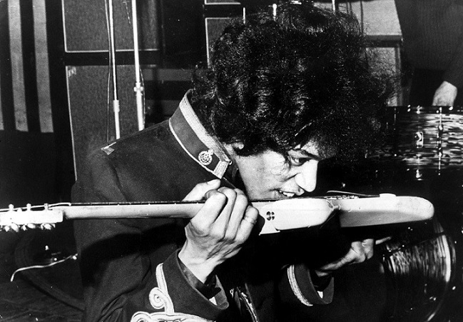 Hendrix in uno scatto degli Anni Sessanta in cui suona la chitarra con i denti (Keystone)