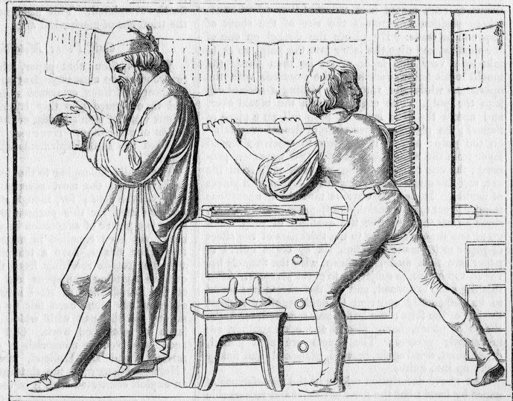 Dove tutto ebbe inizio: Johann Gutenberg (1400-1468) legge delle prove mentre il suo assistente si occupa della pressa – da un bassorilievo sulla tomba di Gutenberg (Keystone)