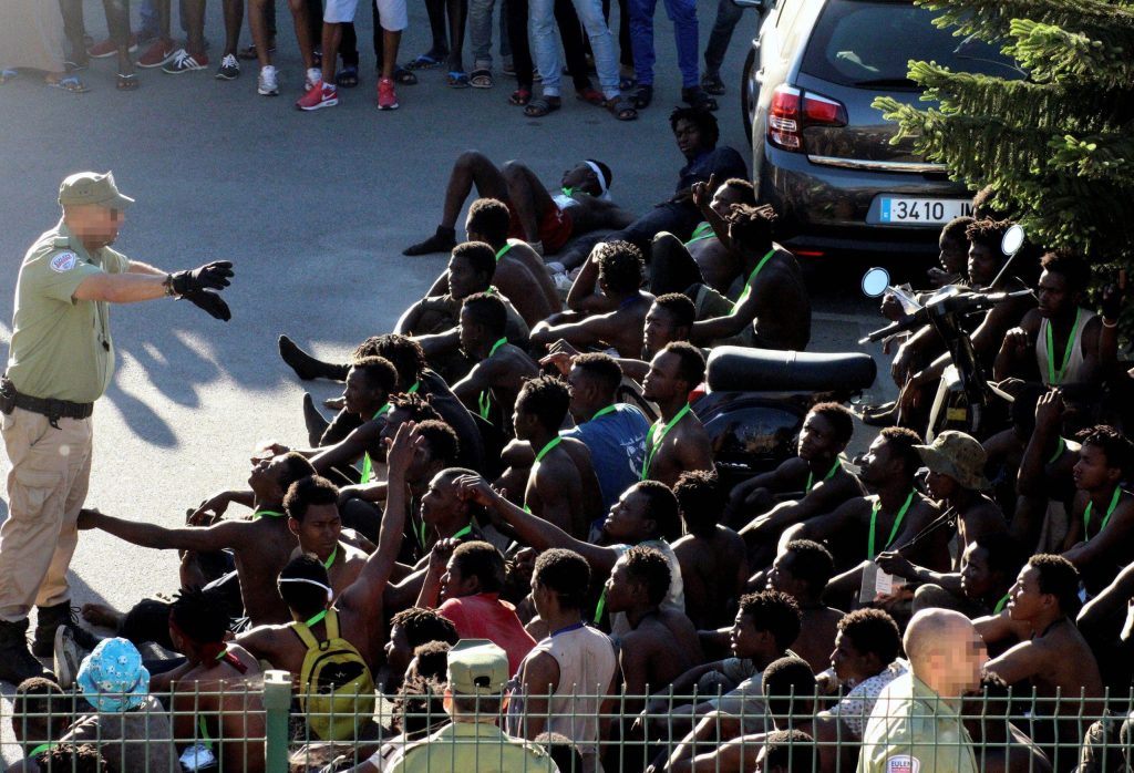 Agenti spagnoli tengono a bada decine di immigrati che sono riusciti a scavalcare la cinta spinata che isola Ceuta, enclave spagnola in Marocco (Keystone)
