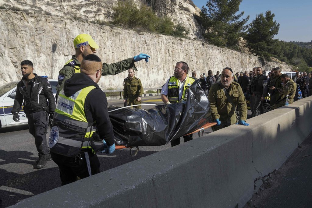 Membri di Zaka e delle forze di sicurezza israeliane trasportano il corpo di un attentatore palestinese nel pressi dell’insediamento cisgiordano di Ma’ale Adumim, alla fine di febbraio 2024 (Keystone)