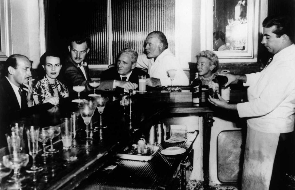 Ernest Hemingway (vestito di bianco, a destra di Spencer Tracy) insieme ad amici al Bar la Floridita, L’Avana, anni 50 (Keystone)