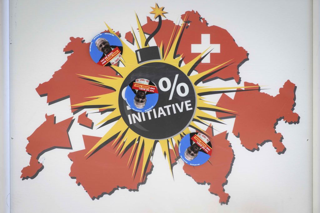 Un manifesto dei contrari all’iniziativa «99%», ricoperto di bollini favorevoli all’iniziativa (Keystone)