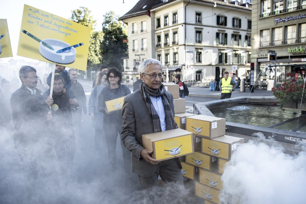 La consegna delle firme per l’iniziativa popolare il 12 settembre 2019, avvenuta a Berna, volutamente avvolta dal fumo (Keystone)