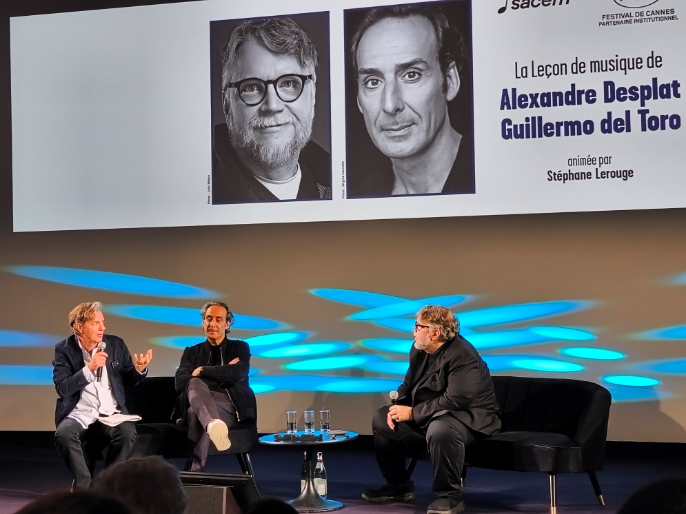 Da sinistra: il moderatore Stéphane Lerouge, giornalista, Alexandre Desplat, compositore di colonne sonore, e Guillermo del Toro, regista.